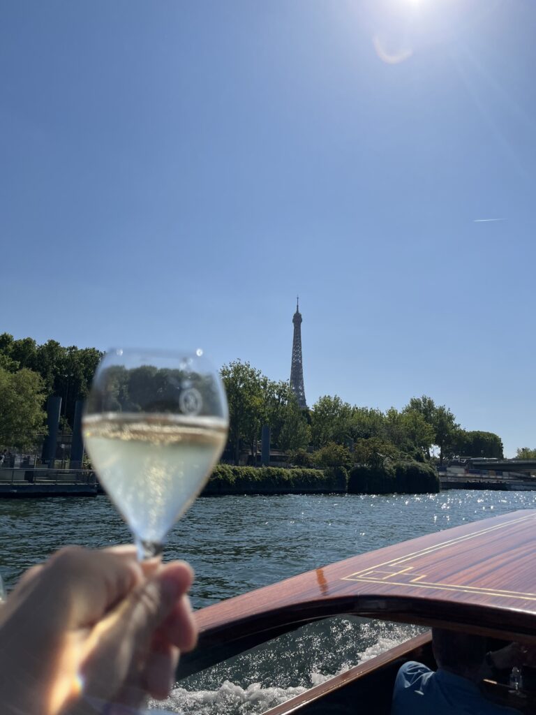 Paris luxury Seine river cruise in a private yath drinking Champaigne with lots of bubbles overlooking the Eiffel tower in nice sunny day during the summes
